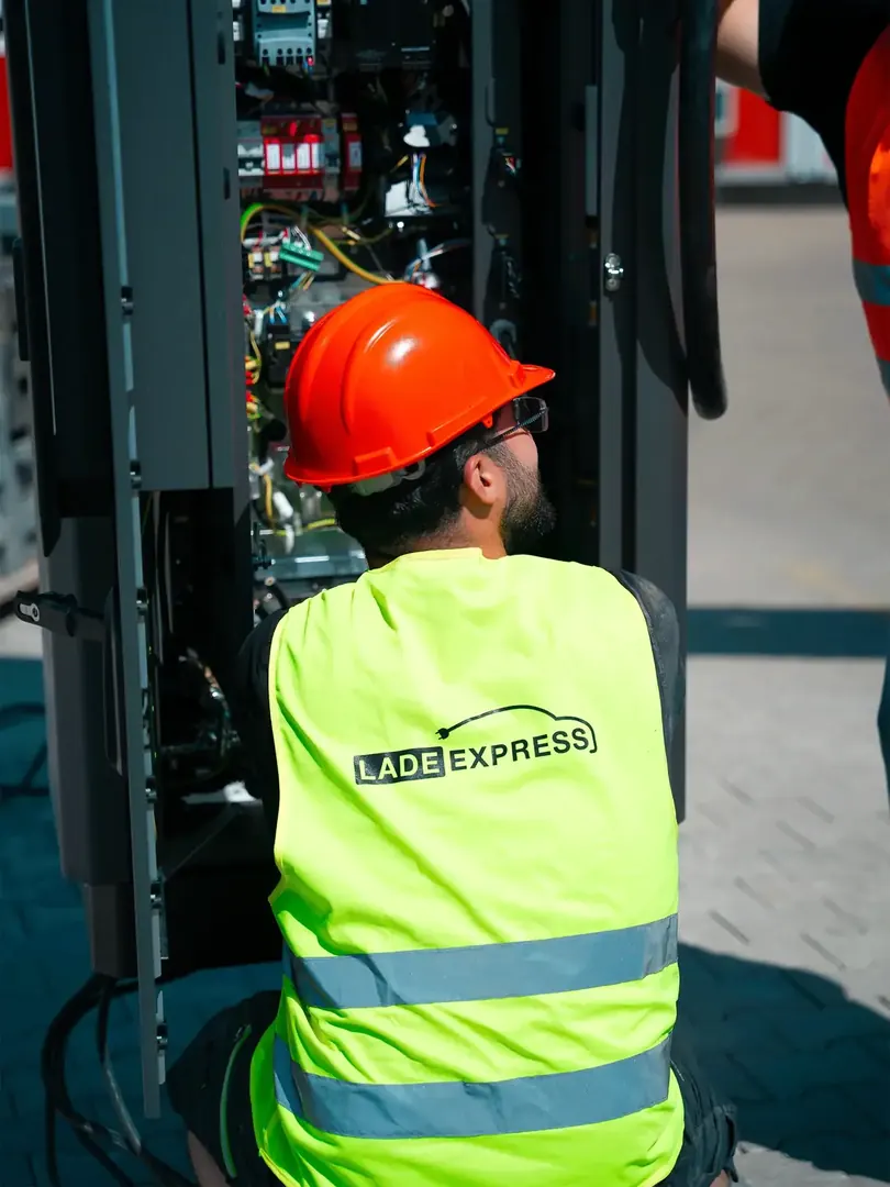 Techniker arbeitet an der geöffneten Technikeinheit einer Ladestation